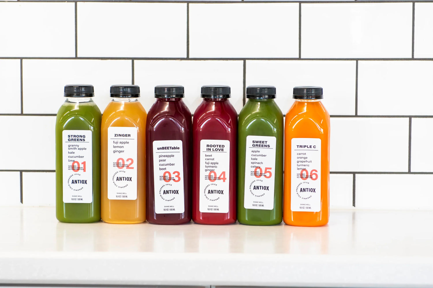 Six numbered ANTIOX cold-pressed juices displayed at the bar